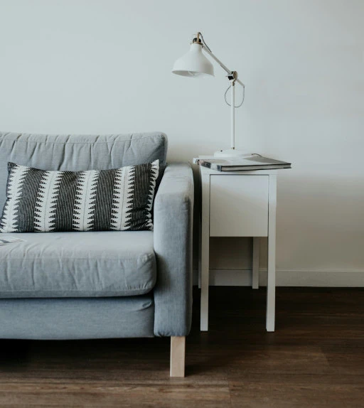 grey couch with a white end table